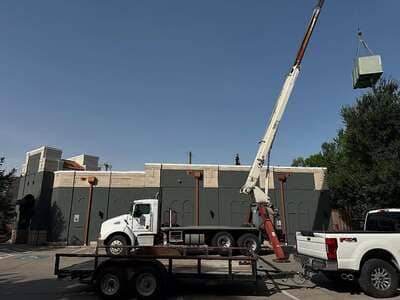 Crane truck setting a rooftop unit